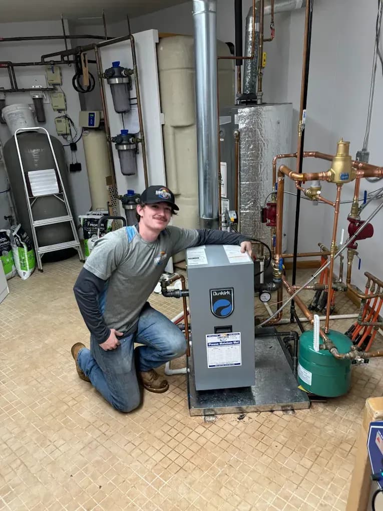 A Climate Control Services technician beside an HVAC installation